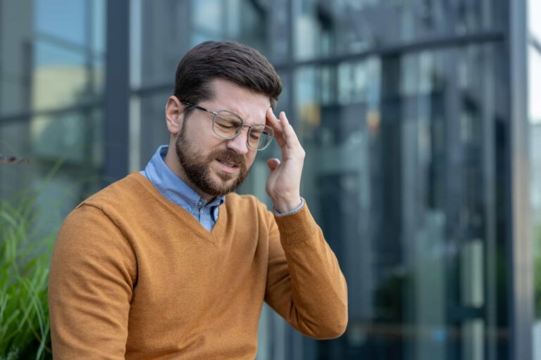 sykemelding - mann holder seg til hodet