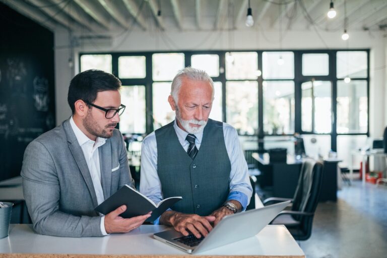 generasjonsskifte familiebedrift - far og sønn ser på en pc