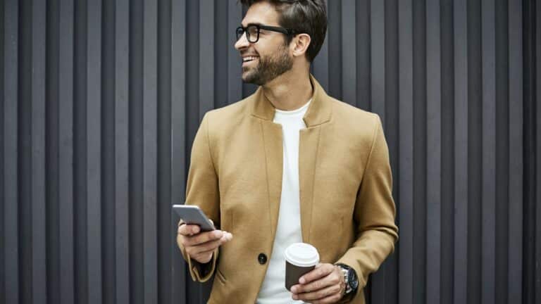 skattekontroll og bokettersyn - mann holder en kaffe og en telefon