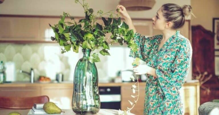 boligstyling - kvinne som setter blomster i en vase