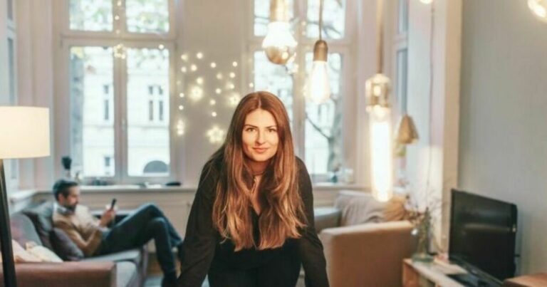 eiendomsoppgjør - kvinne sitter i stuen og ser mot kamera