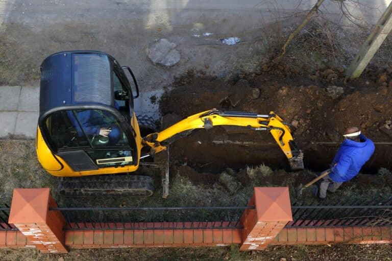 naboen graver på min tomt, naboen tar seg til rette - gravemaskin som graver utenfor et hus