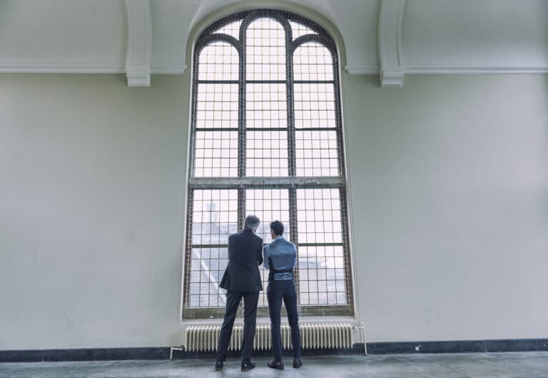 innsigelse mot varemerke - to personer som står ved et stort vindu