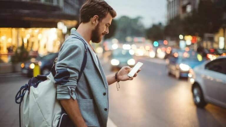 erstatning ved personalforsikring - mann ser på telefon i trafikken