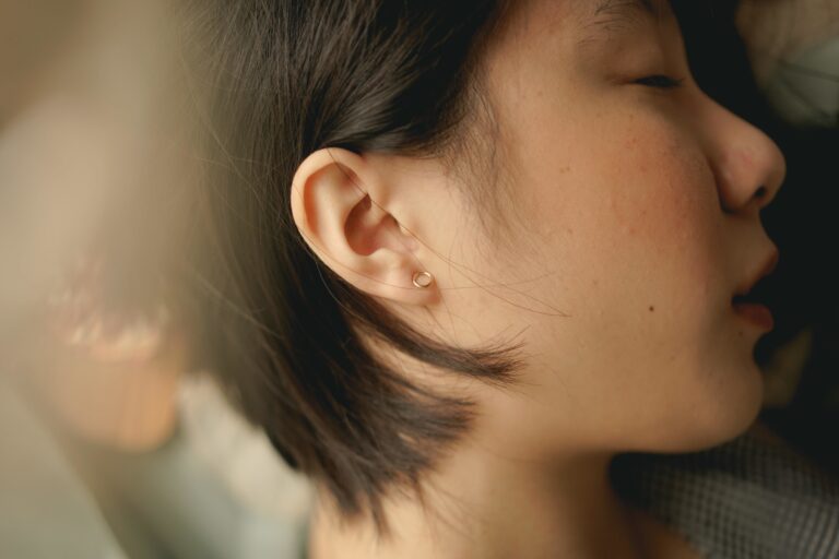 erstatning ved tinnitus - kvinne som ligger med hodet på en pute