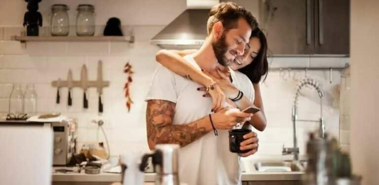 innboforsikring - et par ser sammen på telefonen på kjøkkenet