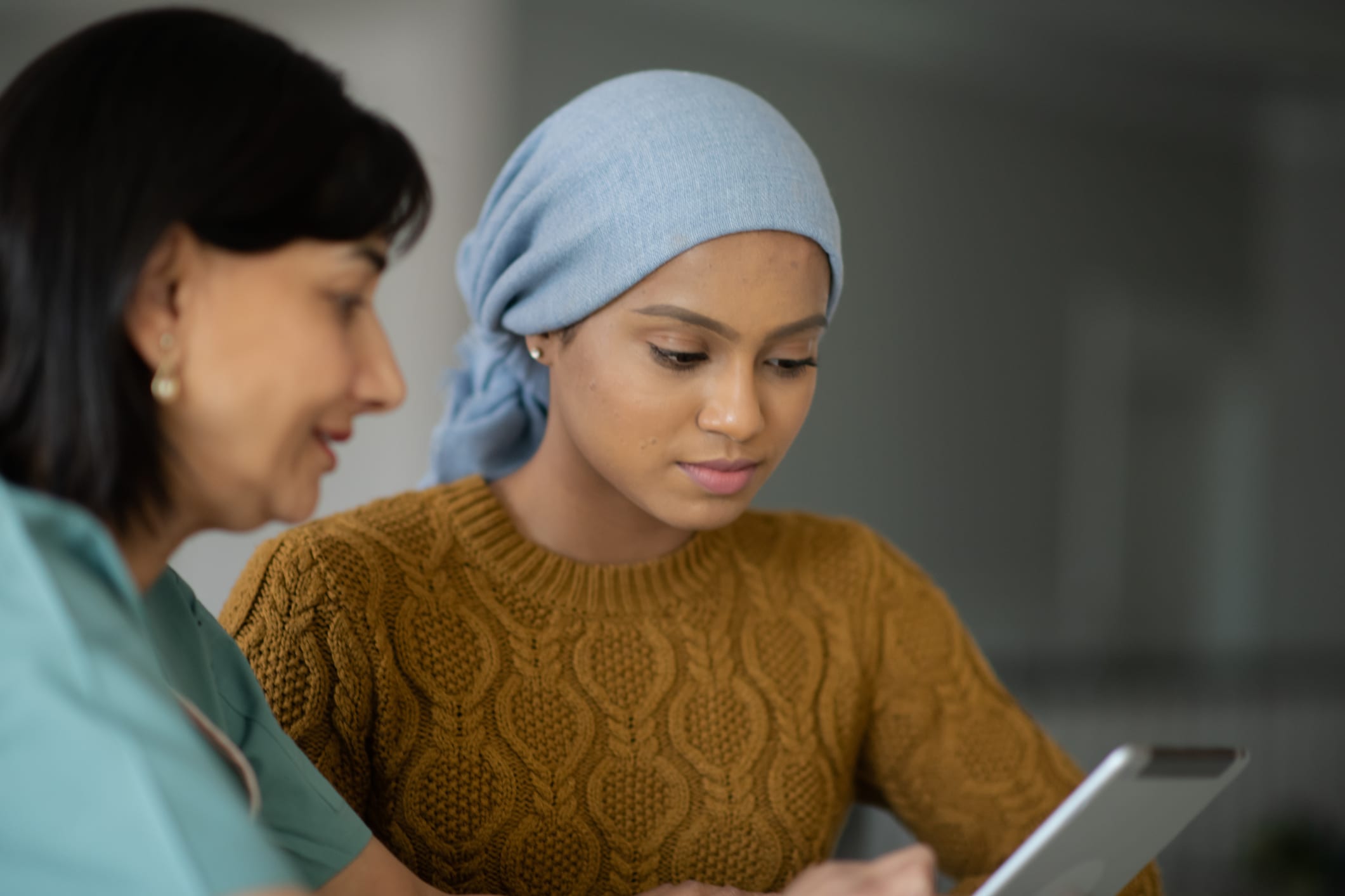 trygderett - dame ser på en ipad sammen med en annen dame