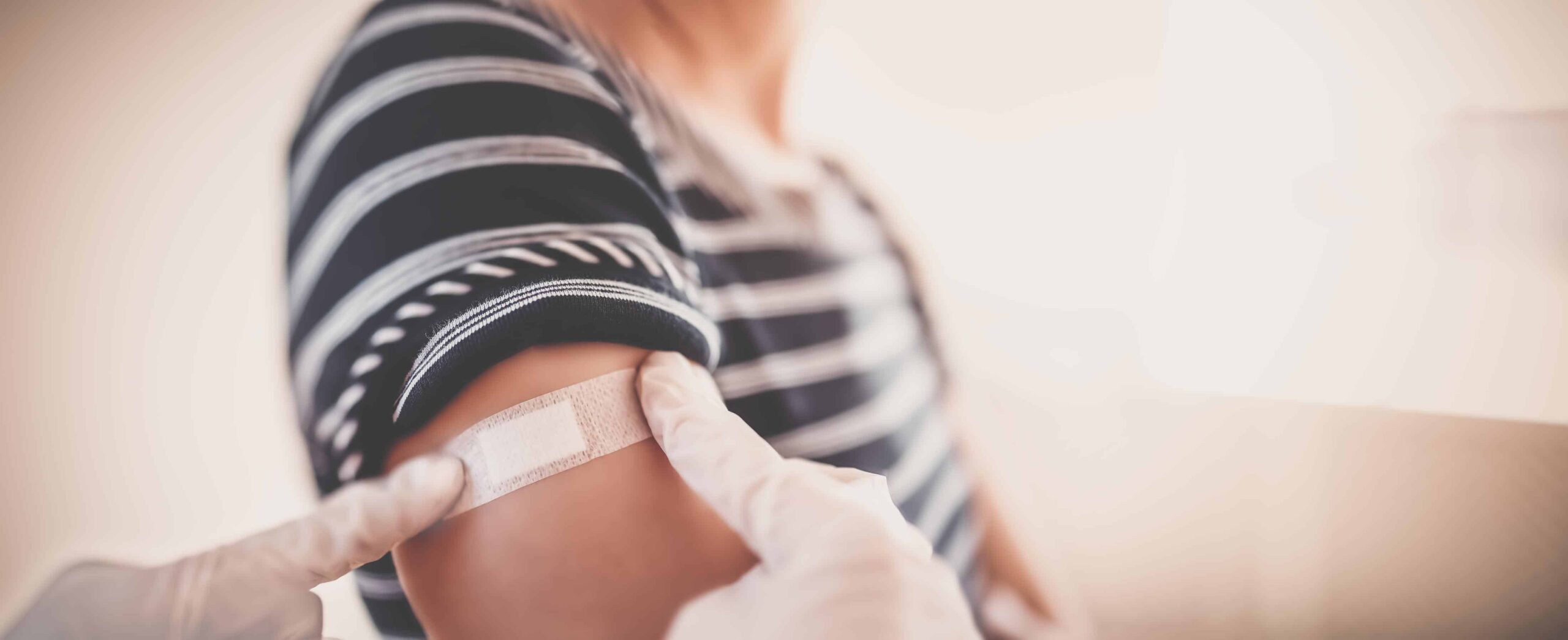 vaksineskade - person som får plaster på armen