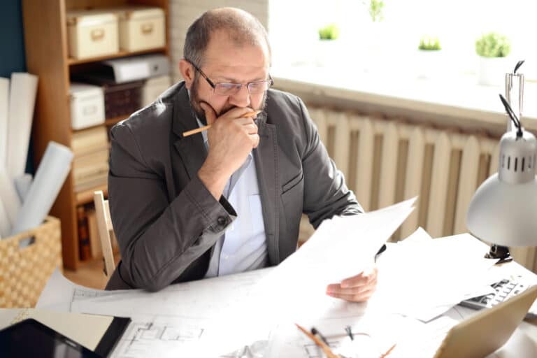 slakk og forsinkelse - mann leser papirer