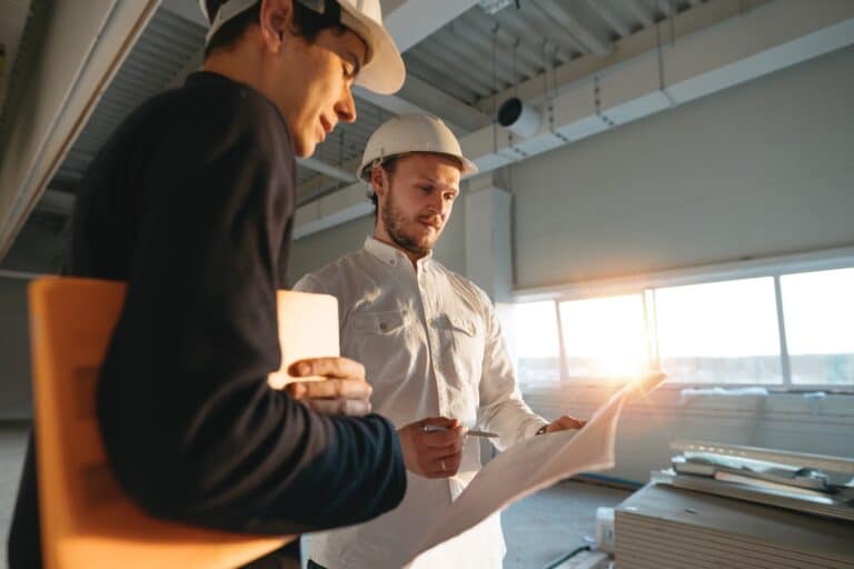 vederlagsjustering og prisregulering - to personer diskuterer over et ark