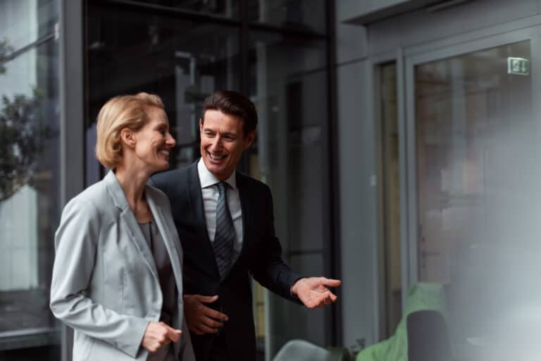 kjøp og salg av eiendomsaksjeselskap - to personer som snakker utenfor en bygning