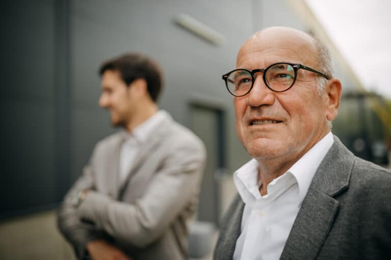 aksjeselskap egenkapital og likviditet - eldre mann med en yngre mann i bakgrunnen