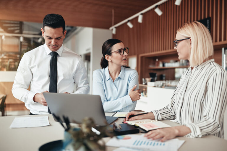 emisjon - tre personer som snakker samme i et kontorlandskap