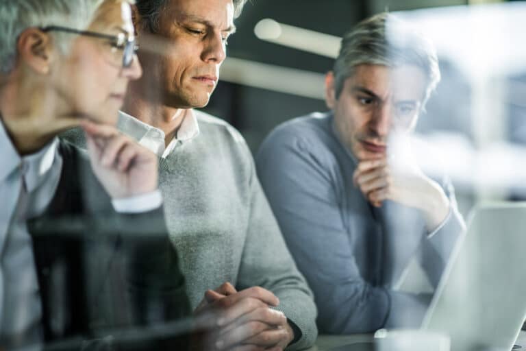 erstatningsansvar - tre personer ser på en pc