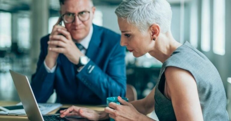 restrukturering og insolvens - to personer som ser på en pc