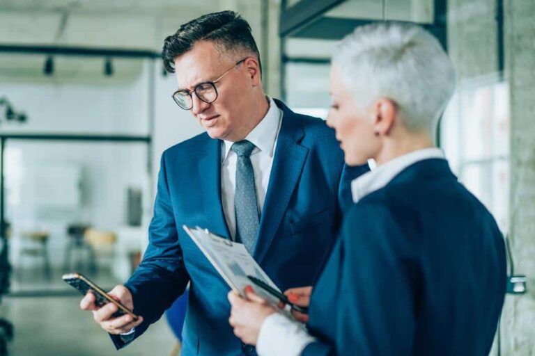 kontrakter - forretningsmann som leser noe på telefonen