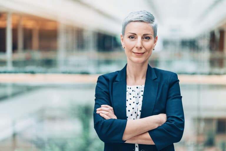 krav på erstatning - kvinne som står i et kontorbygg med hendene i kryss